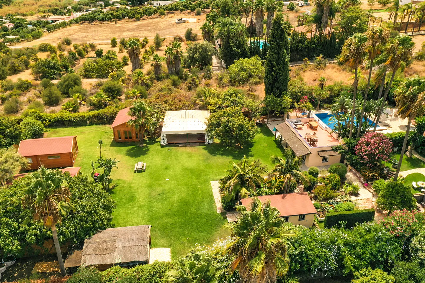An overview of Finca Tierra Sana — the estate's gardens, pool and country buildings set among palms with the hills beyond