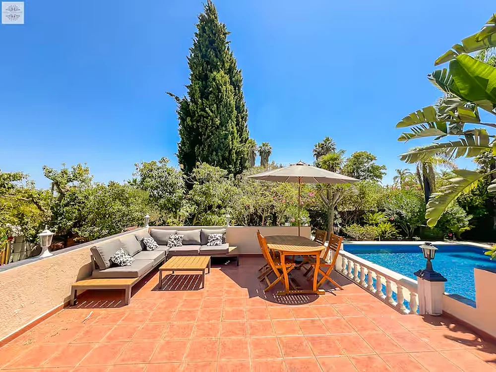 An evening dining terrace set on the villa rooftop at dusk